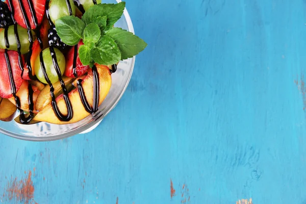 Välsmakande fruktsallad på blå träbord — Stockfoto