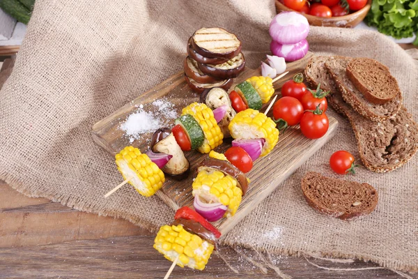 Legumes fatiados em picaretas de madeira e pão na mesa close-up — Fotografia de Stock