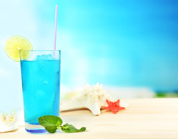 Erfrischender Cocktail auf Holztisch auf blauem Hintergrund — Stockfoto