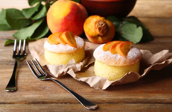 Смачні міні торти зі свіжим персиком, на дерев'яному столі — стокове фото