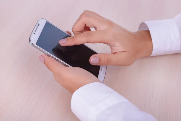 Mujer usando smartphone sobre fondo claro — Foto de Stock