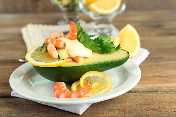 Salade savoureuse aux crevettes et avocat sur assiette, sur fond de bois — Photo