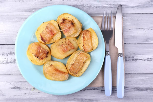Bakad potatis med bacon på plattan, på trä bakgrund — Stockfoto
