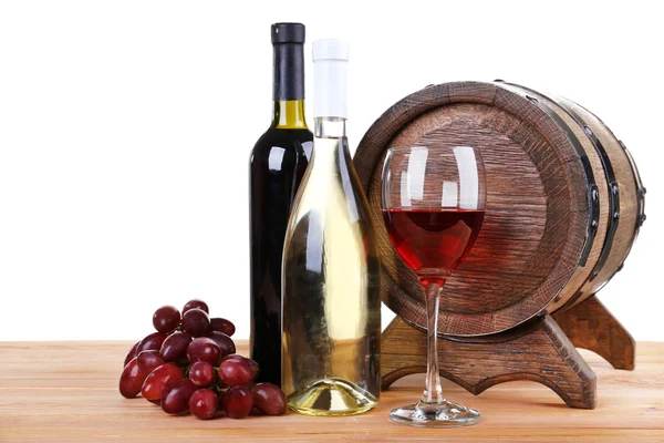 Wino w czara i w butelkach, winogron i beczki na drewnianym stole na białym tle — Zdjęcie stockowe