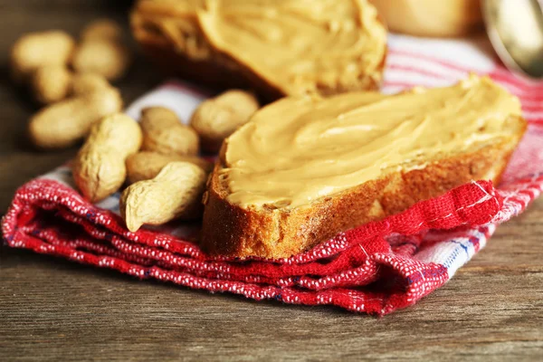 Sandwich savoureux au beurre d'arachide frais sur fond de bois — Photo