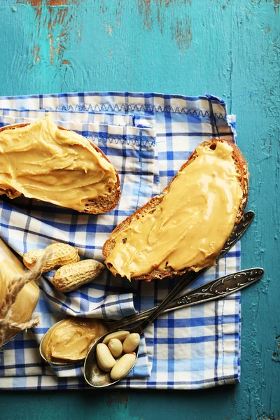 Roti lapis lezat dengan selai kacang segar di latar belakang kayu — Stok Foto