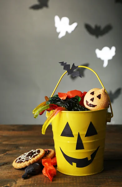 Diferentes dulces para fiesta de Halloween en mesa de madera, sobre fondo oscuro —  Fotos de Stock