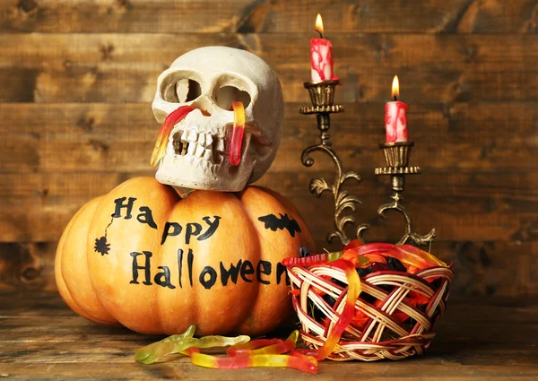 Halloween-Kürbis und Bonbons im Korb auf Holztischhintergrund — Stockfoto