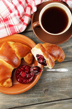 Çay ve ahşap arka plan üzerinde büyük taze kruvasan kahvaltı