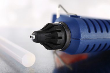 Koyu mavi silah ve silikon yapıştırıcı ışık arka plan üzerinde