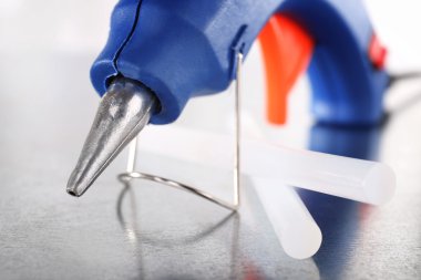 Koyu mavi silah ve silikon yapıştırıcı ışık arka plan üzerinde