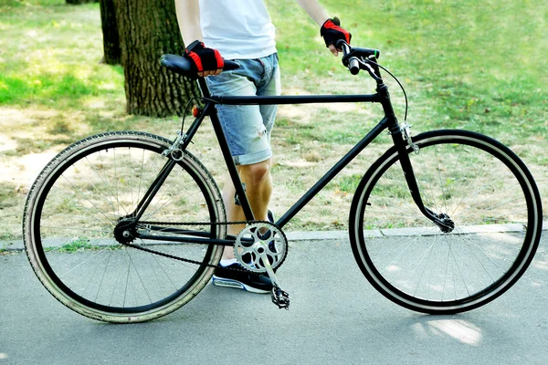 Young man riding bike in city park — Stock Photo, Image