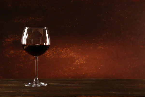 Goblet of red wine on wooden table on wooden wall background — Stock Photo, Image