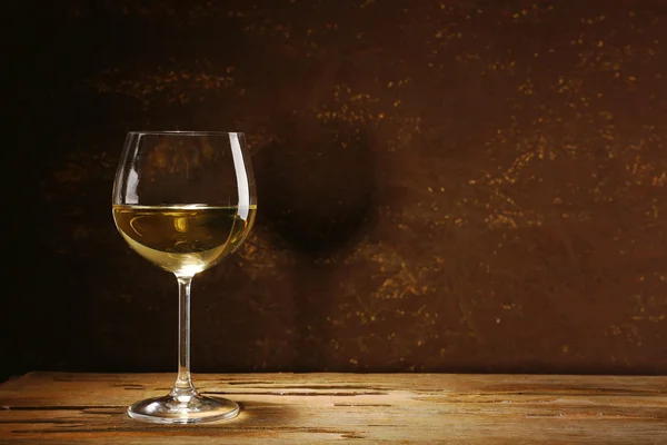 Goblet of white wine on wooden table on wooden wall background — Stock Photo, Image