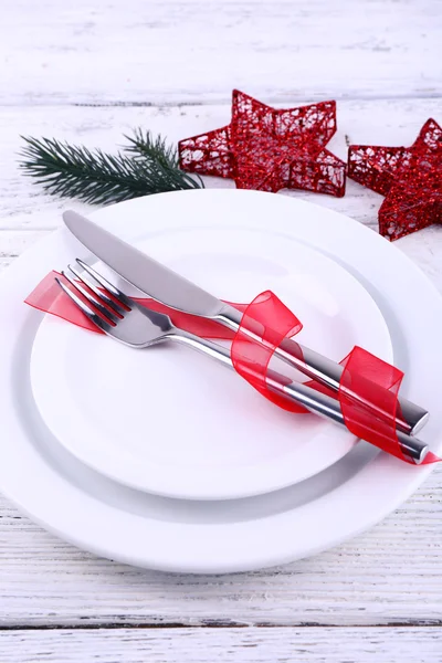 White plates, knife, fork, napkin and Christmas decoration on wooden background — Stock Photo, Image