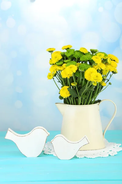 Żółte i zielone kwiaty w wazonie na drewnianym stole, na jasnym tle — Zdjęcie stockowe