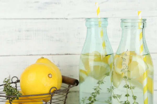 Tasty cool beverage with lemon and thyme, on wooden background — Stockfoto