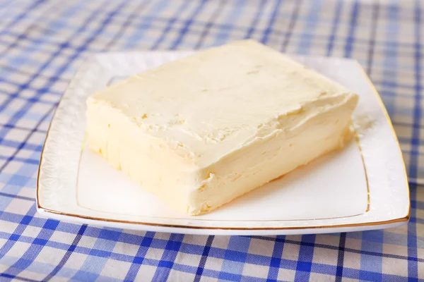 Färskt smör på plattan, på tabellbakgrund — Stockfoto