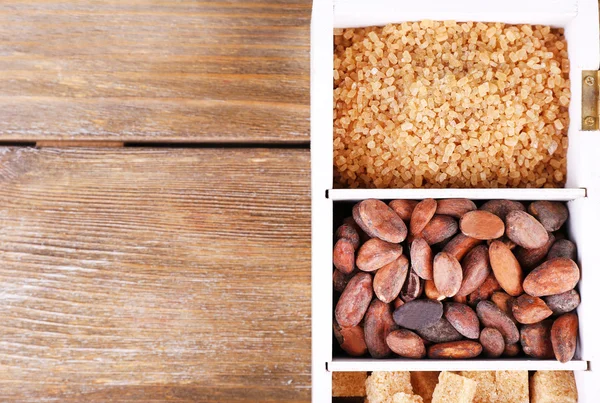 Holzkiste mit Kaffee- und Kakaobohnen-Set, Zuckerwürfel auf Holzgrund — Stockfoto