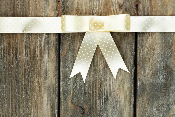 Old wooden background with beautiful bow — Stock Photo, Image