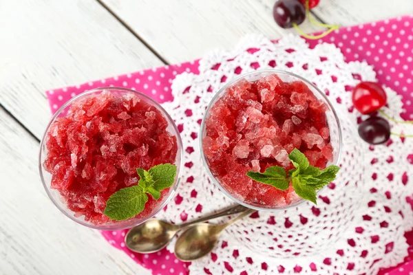 Closeup of cherry granita in glass bowl, on color wooden background — Stock Photo, Image