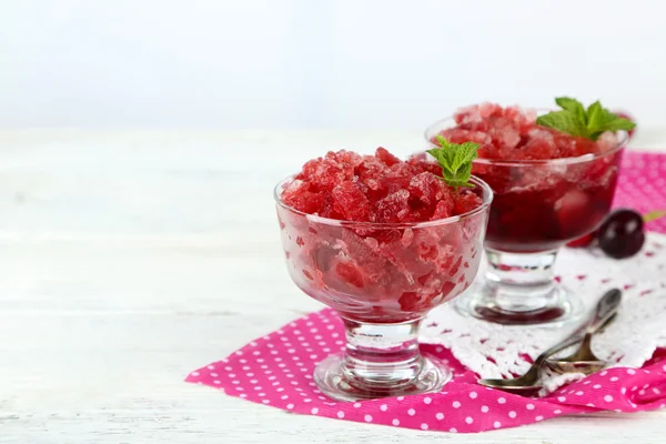 Closeup of cherry granita in glass bowl, on color wooden background — Stock Photo, Image