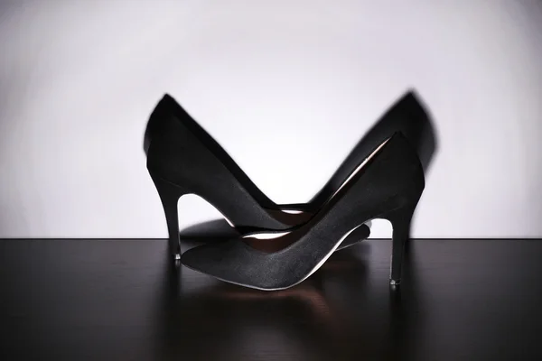 Par de sapatos pretos da mulher no chão no fundo da parede leve — Fotografia de Stock