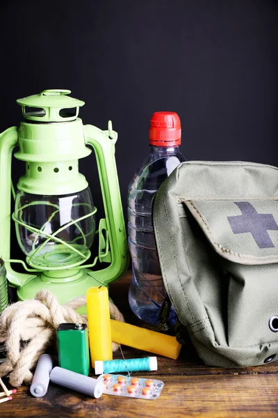 Emergency preparation equipment on wooden table, on dark background — Stock Photo, Image