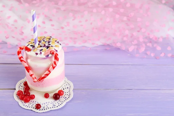 Dessert al latte di mirtillo rosso in vaso di vetro, su tavolo di legno a colori, su sfondo brillante — Foto Stock