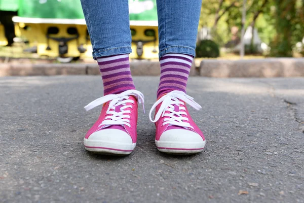 Kvinnliga ben i färgglada strumpor och sneakers utomhus — Stockfoto