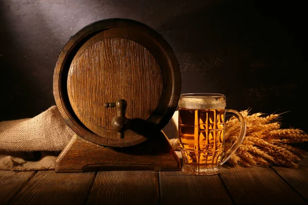 Öl fat med öl glas på bord på trä bakgrund — Stockfoto