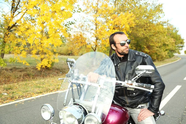 Biker man sits on bike — Stock Photo, Image