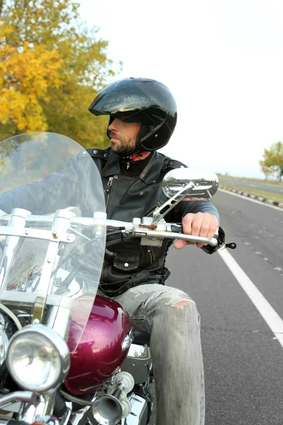 Homme motard en casque noir assis sur le vélo — Photo