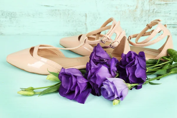 Beautiful woman shoes with flowers on wooden background — Stock Photo, Image