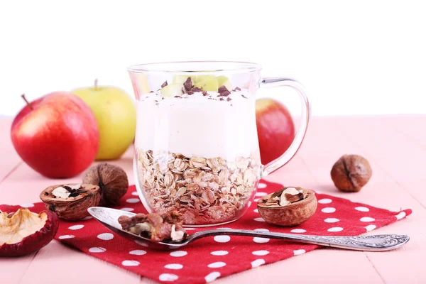 Harina de avena con yogur en jarra, manzanas y nueces en servilleta de lunares sobre mesa de madera rosa sobre fondo claro —  Fotos de Stock