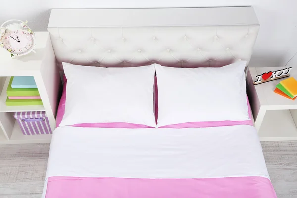 Ліжко в рожевій постільній білизні в кімнаті — стокове фото