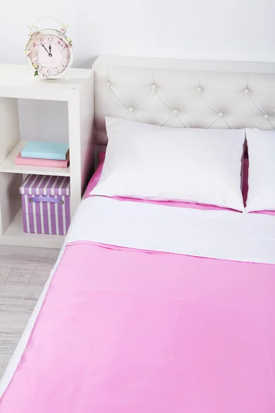 Ліжко в рожевій постільній білизні в кімнаті — стокове фото
