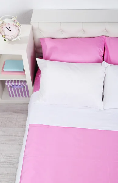 Bett in rosa Bettwäsche im Zimmer — Stockfoto