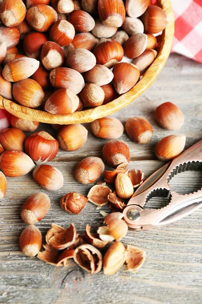 Hazelnuts in wicker basket on wooden background — Stock Photo, Image