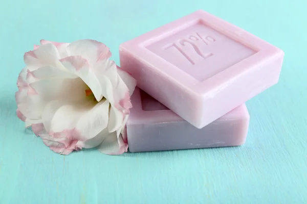 Bars of natural soap with fresh flowers on wooden background — Stock Photo, Image