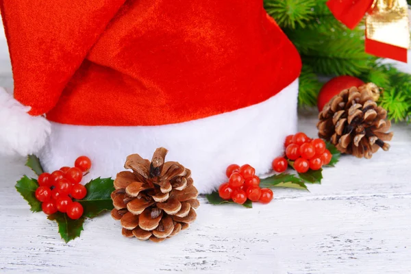 Feuilles de gui avec chapeau de Noël sur la table sur fond de mur de briques — Photo