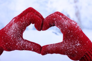 Kadının kış doğal zemin üzerine kırmızı eldiven eller