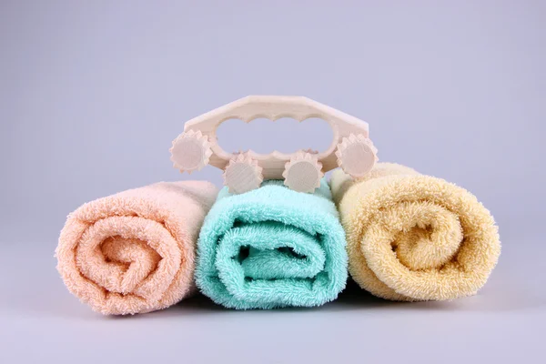 Wooden roller brush and towels on grey background — Stock Photo, Image