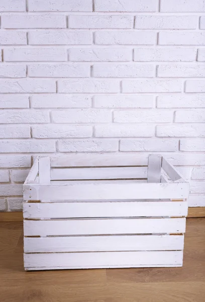 Caja de madera sobre fondo de pared de ladrillo blanco —  Fotos de Stock