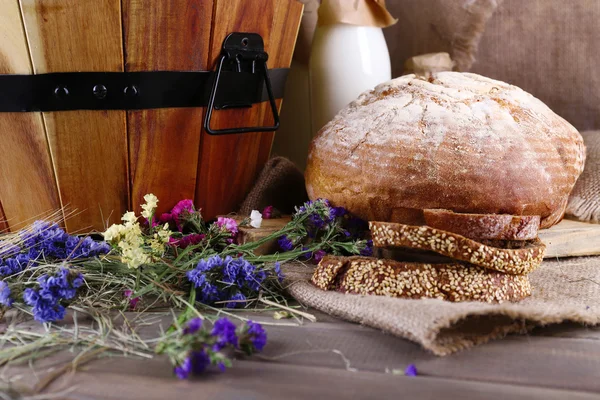 Grande cesto di legno con fiori secchi e primo piano di latte — Foto Stock