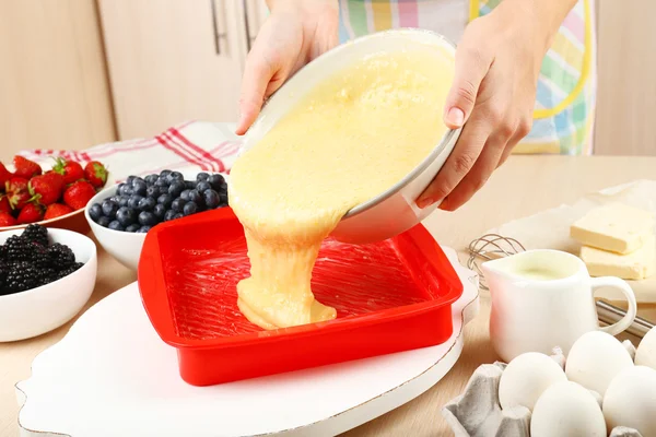 Hornear sabroso pastel e ingredientes para ello en la mesa en la cocina —  Fotos de Stock