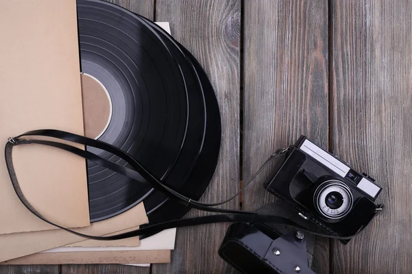 Vinylskivor och papper omslag och kamera på trä bakgrund — Stockfoto