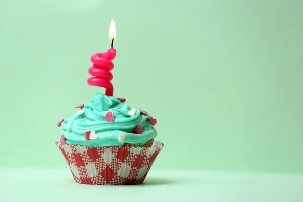 Delicioso cupcake de aniversário na mesa no fundo verde claro — Fotografia de Stock