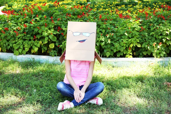 Frau mit Pappschachtel auf dem Kopf mit Gesicht, im Freien — Stockfoto