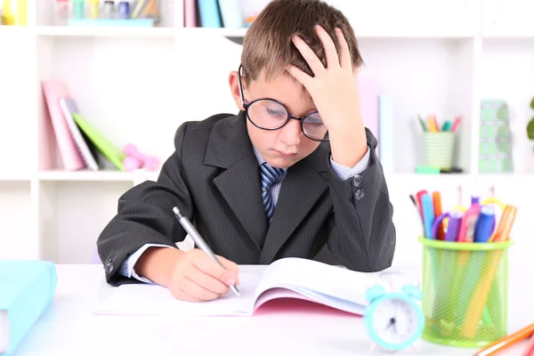 Schooljongen zitten aan tafel in klas — Stockfoto